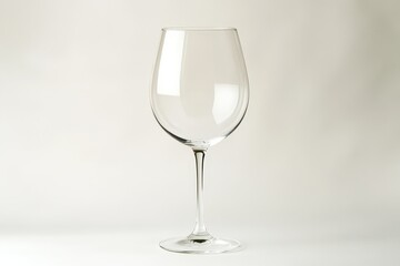 Fototapeta premium A transparent wine glass stands centered on a white background