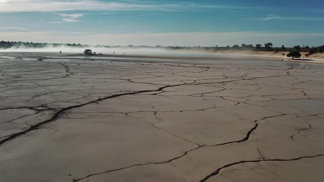 Aerial view of a dried-up lakebed with deep cracks across the parched earth.