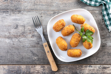 Fried cod croquettes on wooden table. Top view. Copy space