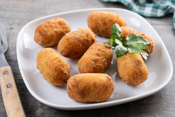Fried cod croquettes on wooden table