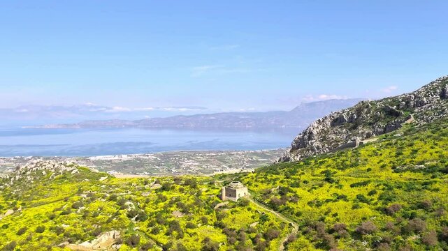 A breathtaking panoramic video captures the stunning Gulf of Corinth from the top of Acrocorinth in Peloponnese, Greece, showcasing sweeping views of the sea, mountains, and historic ruins.