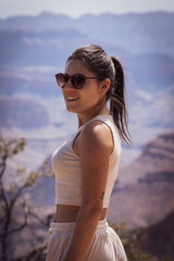 Close-up of a young woman smiling while visiting the wonderful Grand Canyon of the Colorado River in the United States.