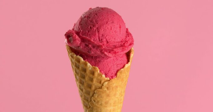 Berry ice cream in a waffle cone close-up footage on the rotating table.