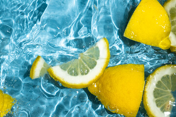 Juicy lemon background of halves and slices of fresh lemons in water.