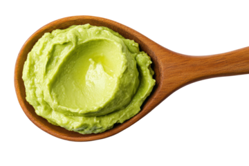 Fresh creamy avocado spread on wooden spoon isolated on black background, cut out