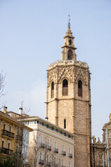 Valencia Cathedral and Miguelete Tower (Micalet) from Plaza de la Reina, Spain. A Gothic masterpiece standing tall, framed by the lively ambiance of one of Valencia’s most iconic squares.