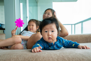 Fototapeta premium A baby is laying on a couch with a pink toy in his hand
