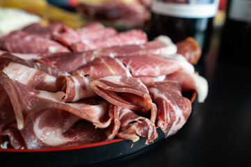A plate of meat and cheese with a black background