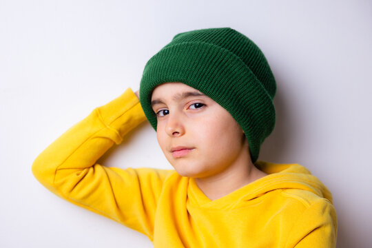 Young child wearing green beanie and yellow hoodie