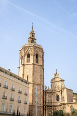 Valencia Cathedral and Miguelete Tower (Micalet) from Plaza de la Reina, Spain. A Gothic masterpiece standing tall, framed by the lively ambiance of one of Valencia’s most iconic squares.