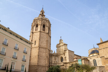 Valencia Cathedral and Miguelete Tower (Micalet) from Plaza de la Reina, Spain. A Gothic masterpiece standing tall, framed by the lively ambiance of one of Valencia’s most iconic squares.