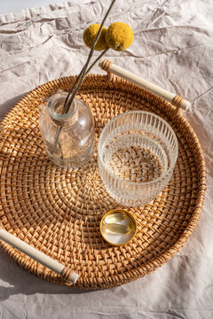 Omega 3 and Vitamin D3 supplements on rattan tray with glass of water
