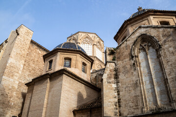 Valencia Cathedral and Miguelete Tower (Micalet) from Plaza de la Reina, Spain. A Gothic masterpiece standing tall, framed by the lively ambiance of one of Valencia’s most iconic squares.