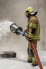 Fototapeta premium a firefighter who puts out fires with foam for public education and demonstration to ordinary people for public education