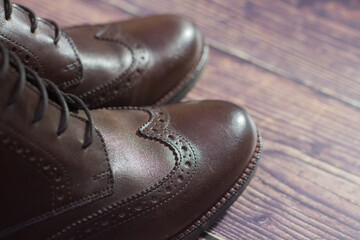 new brown leather shoe with laces on dark background close up