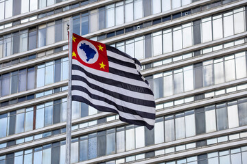 Sao Paulo state flag fluttering in the wind with  building in the background