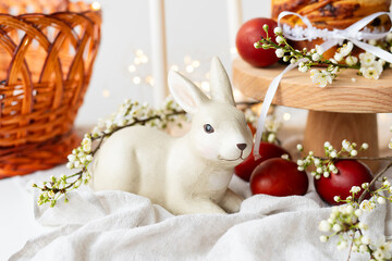A cozy setting with a ceramic bunny, fresh pastries, and flowers, evoking a warm, homely...