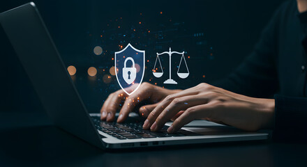 Naklejka premium Hands typing on laptop with justice scale icon hologram overlay on blue background.