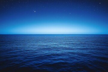 Calm blue sea under a starlit sky during twilight, creating a serene atmosphere at dusk