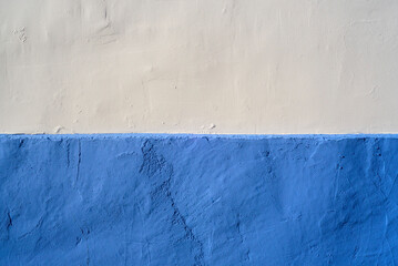 Fachada de casa rural pintada de blanco y azul