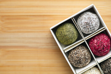 Vegan raw sweet balls on a wooden background. Sugar-free and gluten-free sweets.