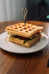 Belgian waffle sandwich with green lettuce, tomato and cheese