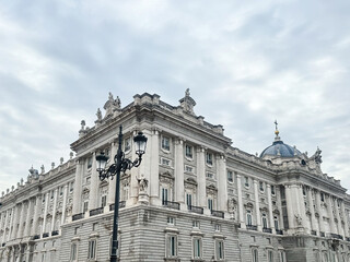 Obraz premium Historical Royal Palace in Madrid, Spain with Visiting Tourists on a Cloudy Day