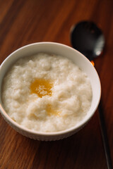 rice porridge with butter on wooden background