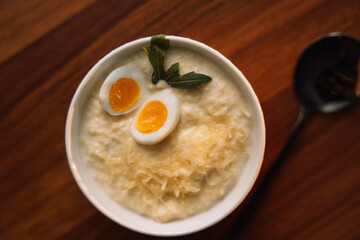 millet porridge with egg in a white bowl on a dark background