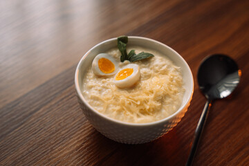 millet porridge with egg in a white bowl on a dark background