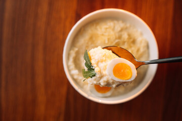 millet porridge with egg in a white bowl on a dark background