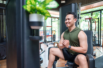 Indonesian southeast asian man training on leg press machine at the gym. Fitness exercise and healthy lifestyle concept