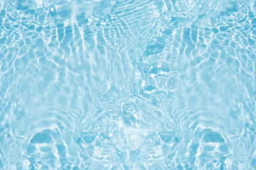 Blue water with ripples on the surface. Defocus blurred transparent blue colored clear calm water surface texture with splashes and bubbles. Water waves with shining pattern texture background.
