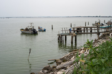 Fototapeta premium Fishing boats near wooden dock in coastal lagoon