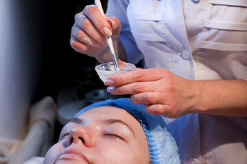 In a cosmetology room, a young woman undergoes a facial treatment (from the series 