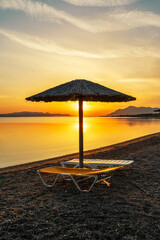 Sunrise on the Beach in the Aegean Sea, Greece with Umbrellas and Sunbeds