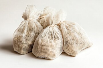 Obraz premium Three mesh bags filled with fresh produce on a white background.