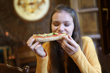 Delicious Pizza Enjoyment A Young Woman Fully Relishing Her Meal and Assets of Happiness
