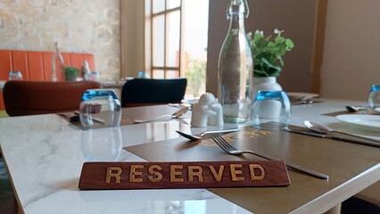 Reserved table in a stylish restaurant with elegant tableware, a glass water bottle, and a cozy ambiance, set for a special dining experience. 