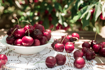 White bowl filled with ripe cherries on the table