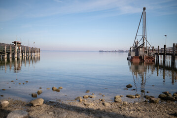 Wooden pier at Chiemsee, Bavaria, Germany. Sunny day, Bavarian Alps in the background. Lake