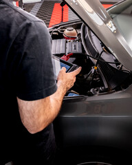 Un escáner de diagnóstico automotriz de diseño moderno conectado a un vehículo mediante un cable, mostrando una pantalla con datos técnicos. La imagen resalta una herramienta esencial en el mantenimie