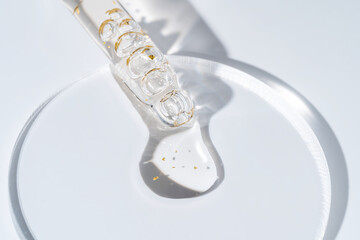 Cosmetic pipette with 24k gold oil on white background close-up. Stylish concept of organic...