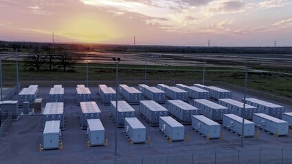 Battery storage farm at sunset. Aerial view of a large outdoor battery storage facility with containers in rows at sunset.