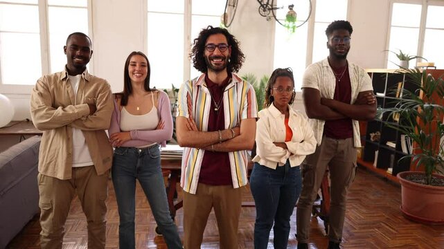 Confident multi ethnic startup founders standing together with crossed arms, embodying team spirit and innovative leadership in modern workspace