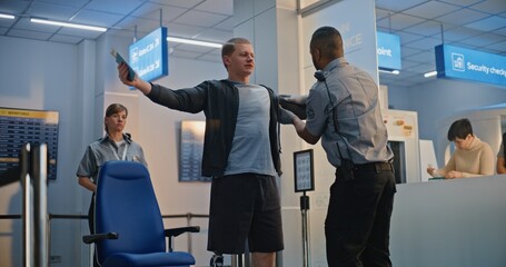 Security Checkpoint in Airport Terminal: African American Security Officer Inspecting Young Man...