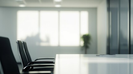 Modern minimalist white conference room with black chairs and empty table, blurred background, close-up of chair, professional setting, natural light.