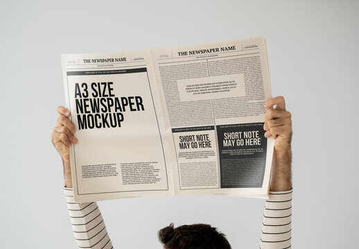 Mockup Of Man Holding Customized A3 Newspaper Above Head