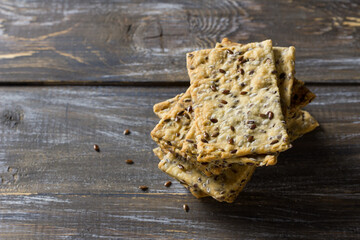 Homemade flaxseed crackers on rustic wooden table, healthy crispbread with seeds