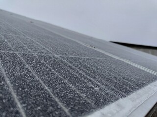 Close-up of frost-covered solar panels on overcast day
